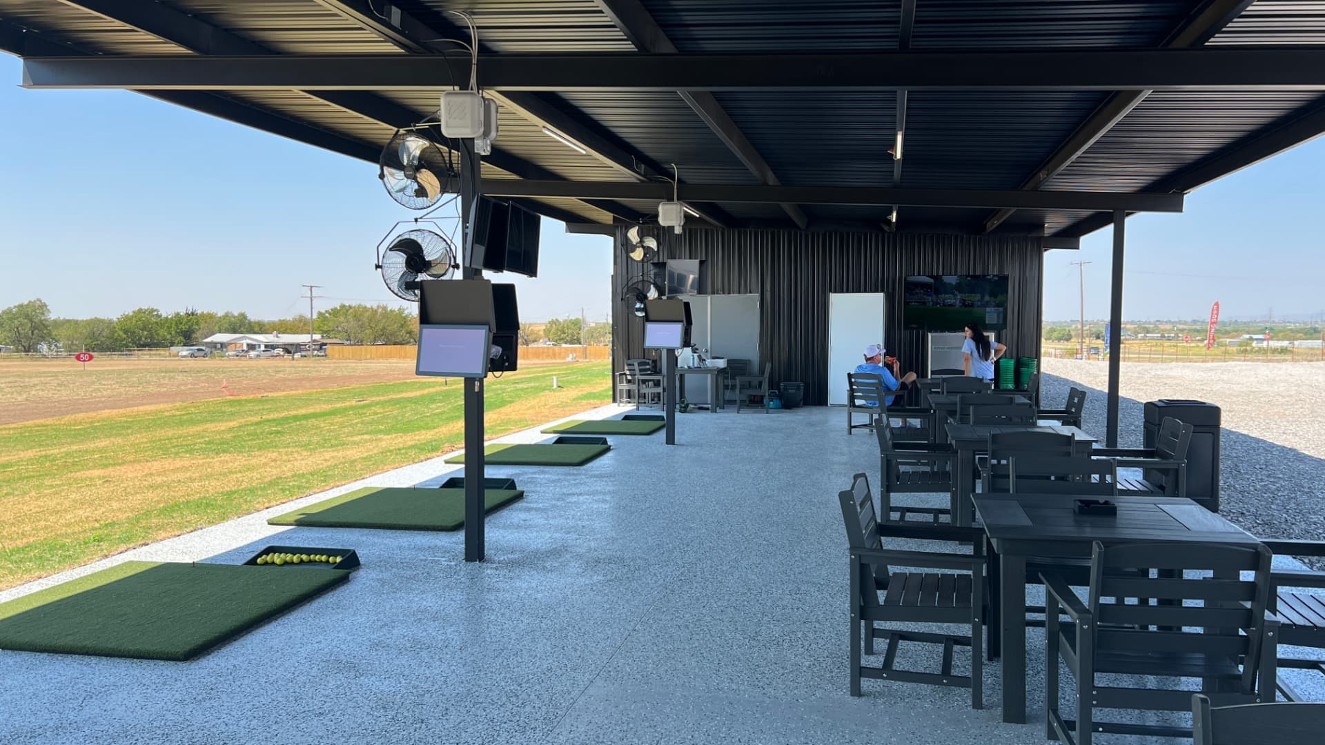 Covered hitting bays with Toptracer screens, seating, and the range